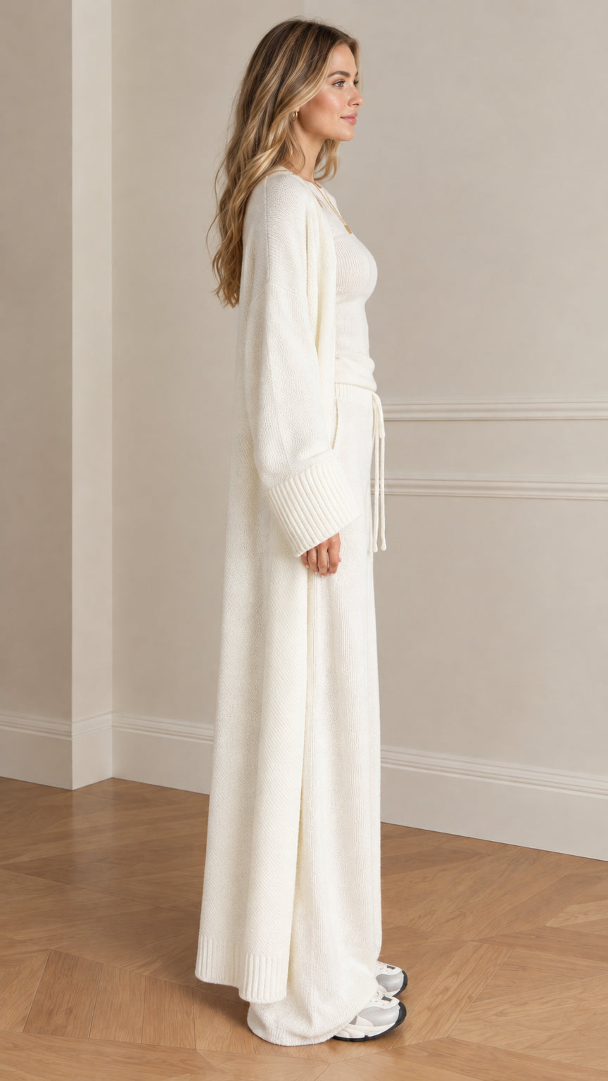 Side profile view of woman wearing cream knit lounge set with long open cardigan