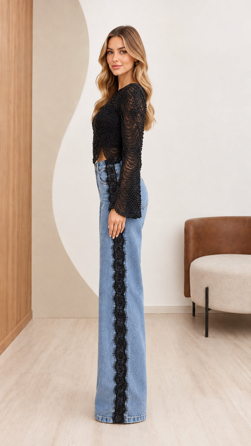 Side view of black beaded crop top and denim jeans featuring black lace side seam trim