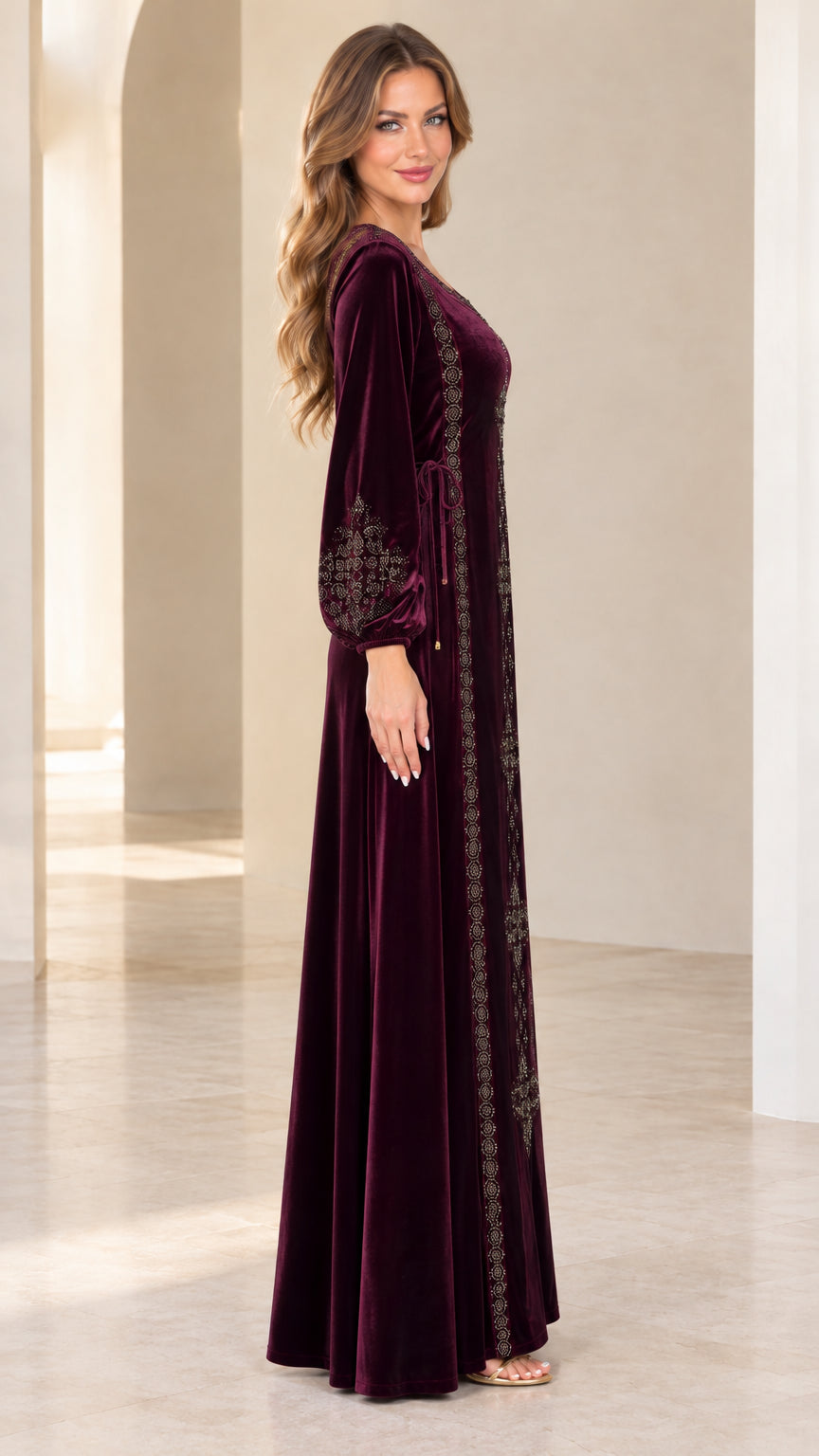Side view of model wearing burgundy long sleeve velvet kaftan dress