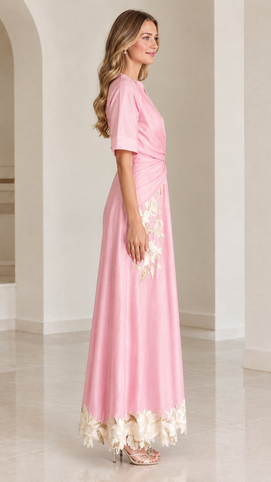 Side profile of woman in pink short-sleeve floral embroidered maxi dress