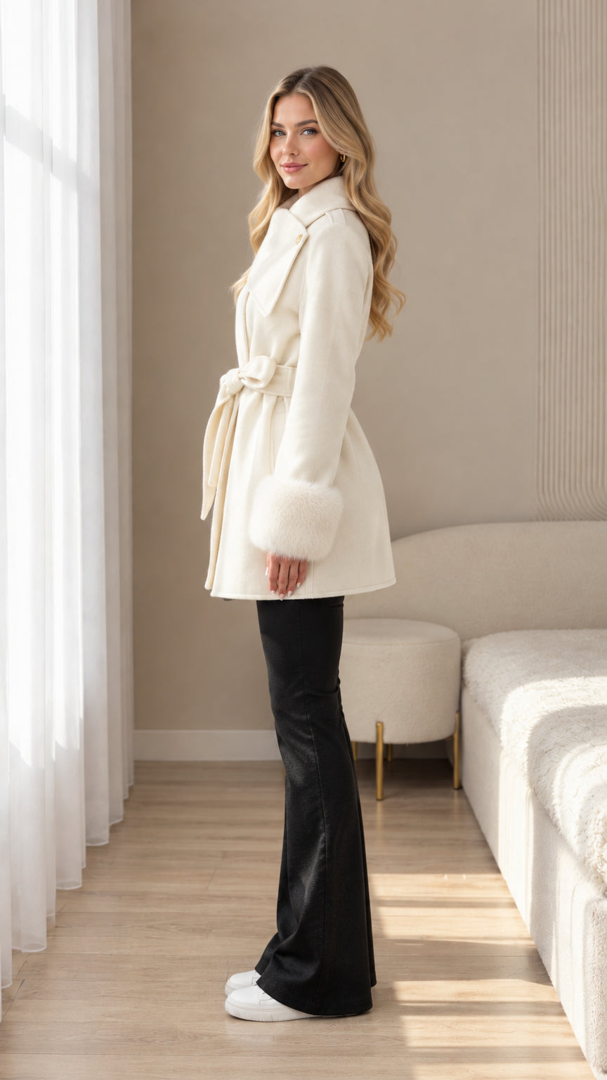 Side profile view of cream mid-length coat with fur cuffs