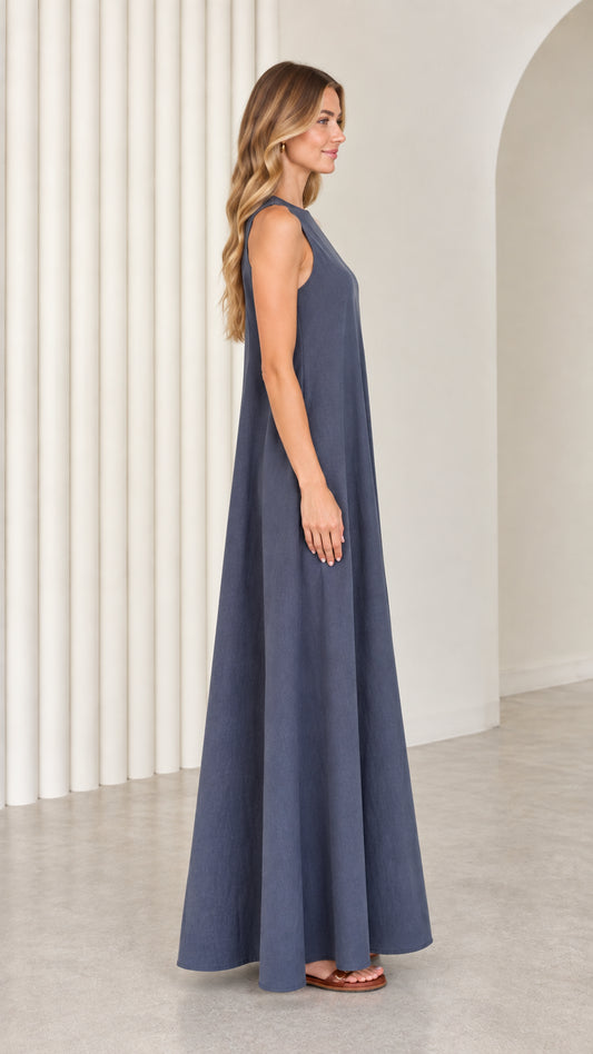 Side profile view of model showcasing the flowing A-line silhouette of the slate blue maxi dress
