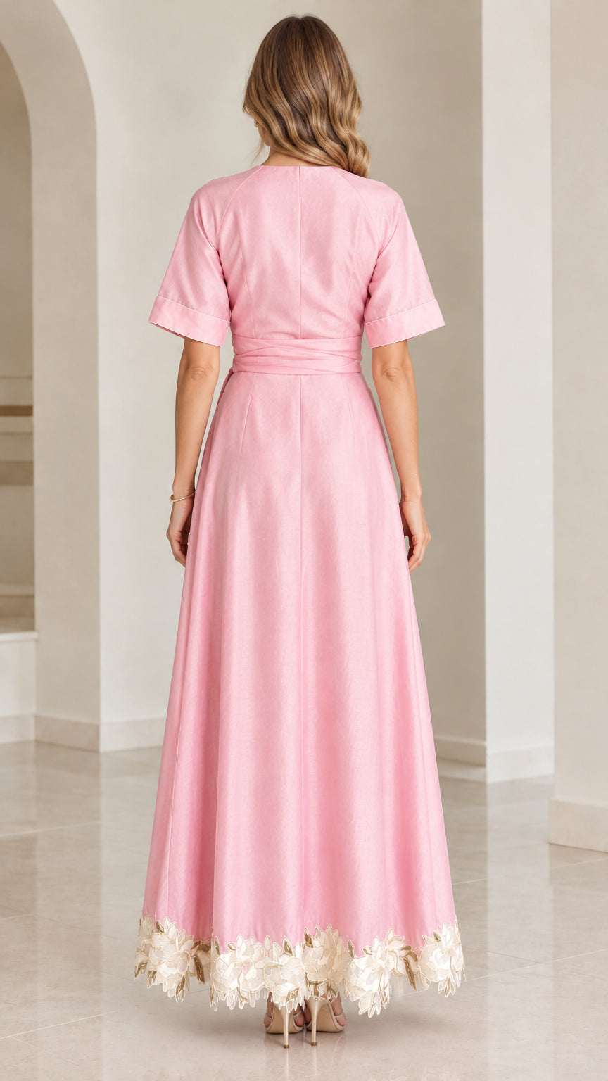 Back view of woman wearing elegant pink A-line maxi dress