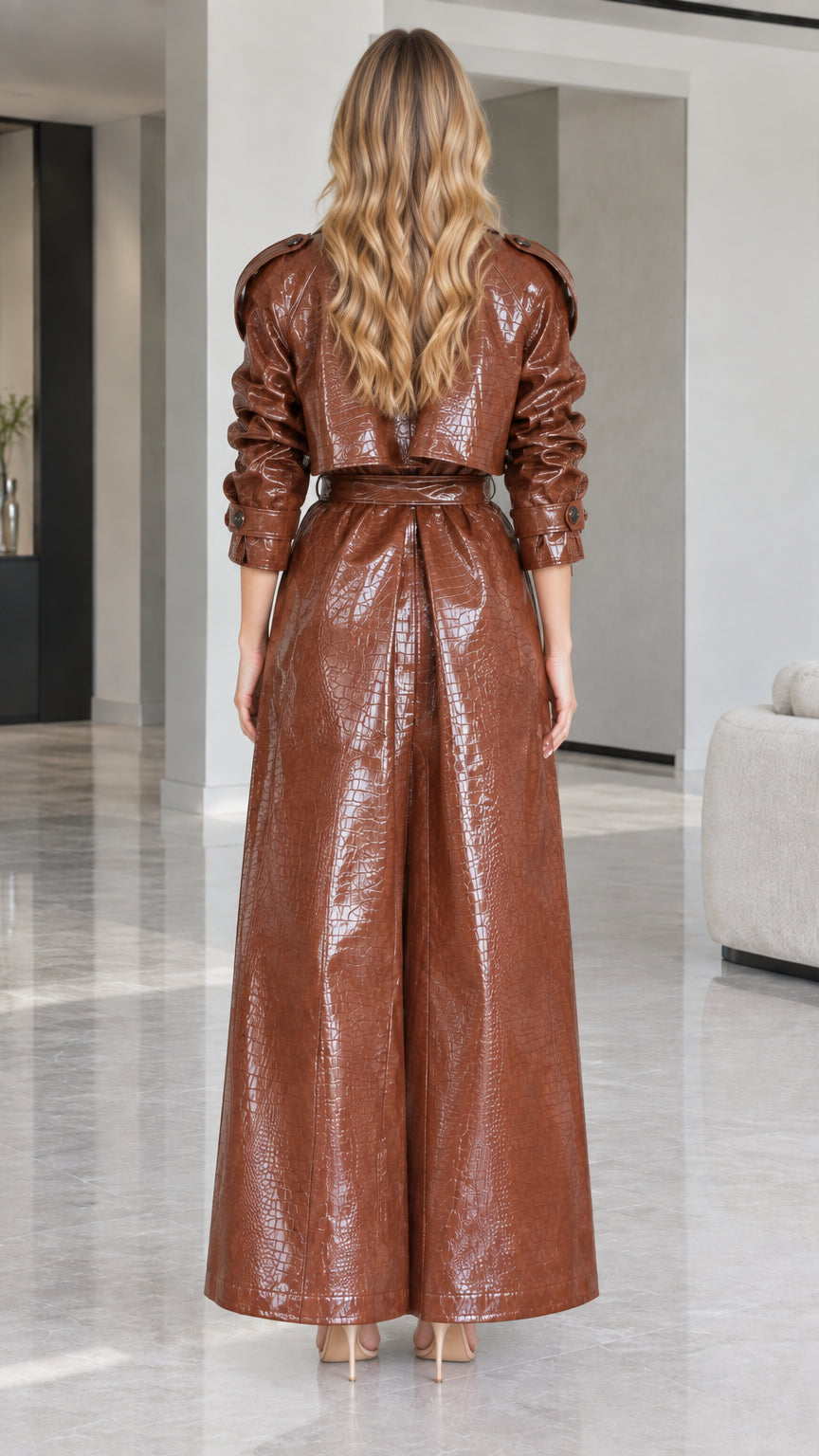 Back view of woman wearing belted Cognac Brown croc-embossed trench coat with back flap detail