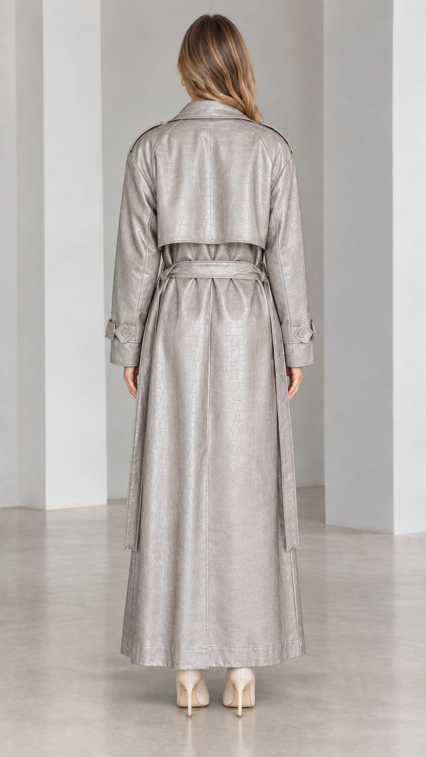 Back view of metallic silver maxi trench coat showing storm flap and belt