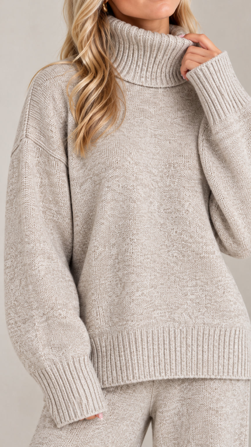 Close-up detail of heather grey ribbed turtleneck collar and knit sweater sleeve texture