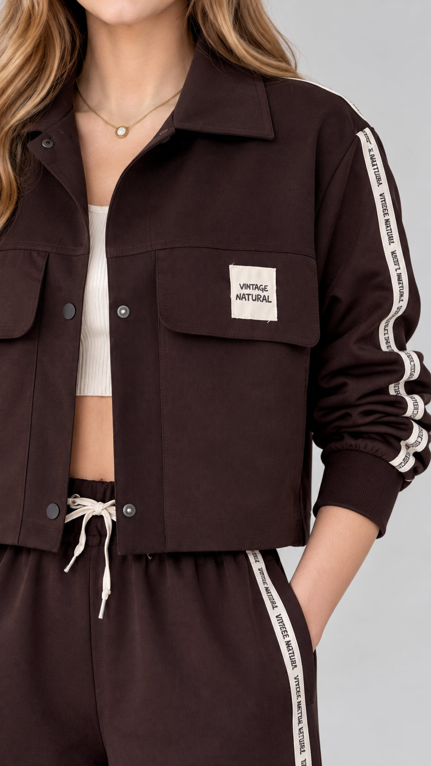 Close-up detail of dark brown cropped jacket with turn-down collar and chest flap pocket