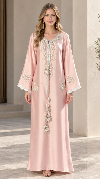 Front full-length view of woman wearing blush pink embroidered kaftan maxi dress with tassels