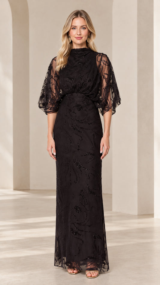 Front view of woman wearing black high-neck beaded maxi evening gown with draped flutter sleeves