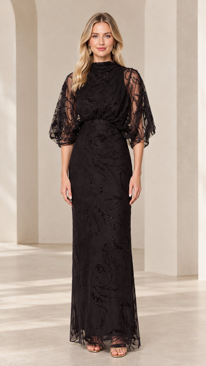 Front view of woman wearing black high-neck beaded maxi evening gown with draped flutter sleeves