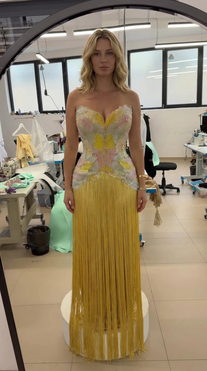 Front view of model wearing the strapless beaded corset fringe gown in yellow