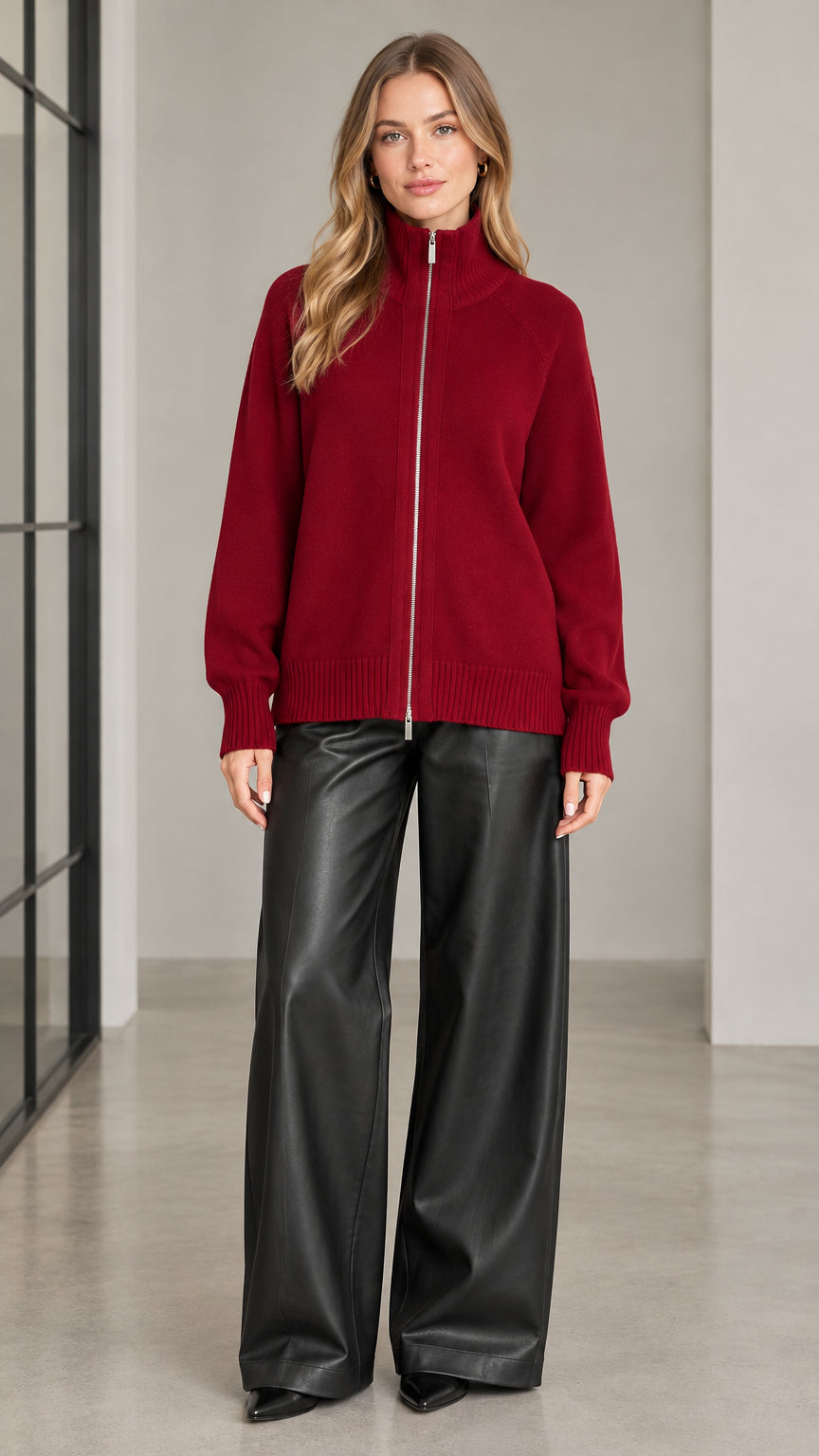 Front view of woman wearing burgundy full zip high neck knit cardigan sweater with wide leg trousers