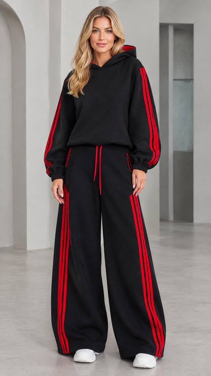 Front view of woman wearing black 2-piece hoodie and wide leg tracksuit set with red stripes