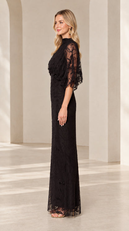 Side profile view of woman modeling black beaded embroidered column maxi dress