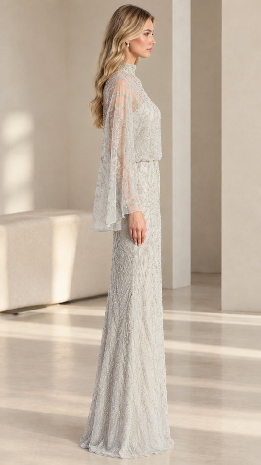 Side profile view of woman wearing silver beaded formal maxi gown with capelet sleeves