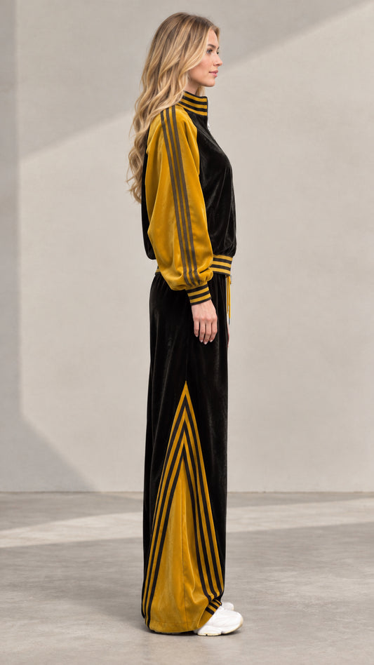 Side profile of women's black and yellow striped velour tracksuit
