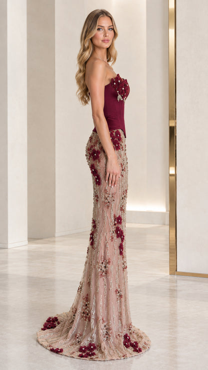Side profile view of burgundy strapless formal evening dress with beaded train