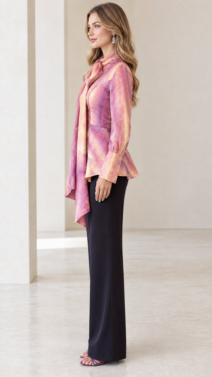 Side profile of model in Blush Pink tie-neck peplum blouse showing draped sash detail