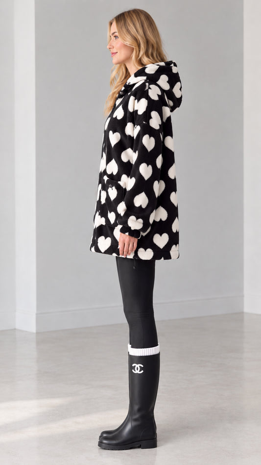 Side view of woman wearing black heart pattern zip-up fleece coat