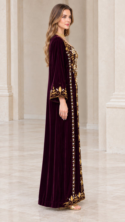 Side profile view of burgundy velvet maxi dress with embellished sleeve cuffs