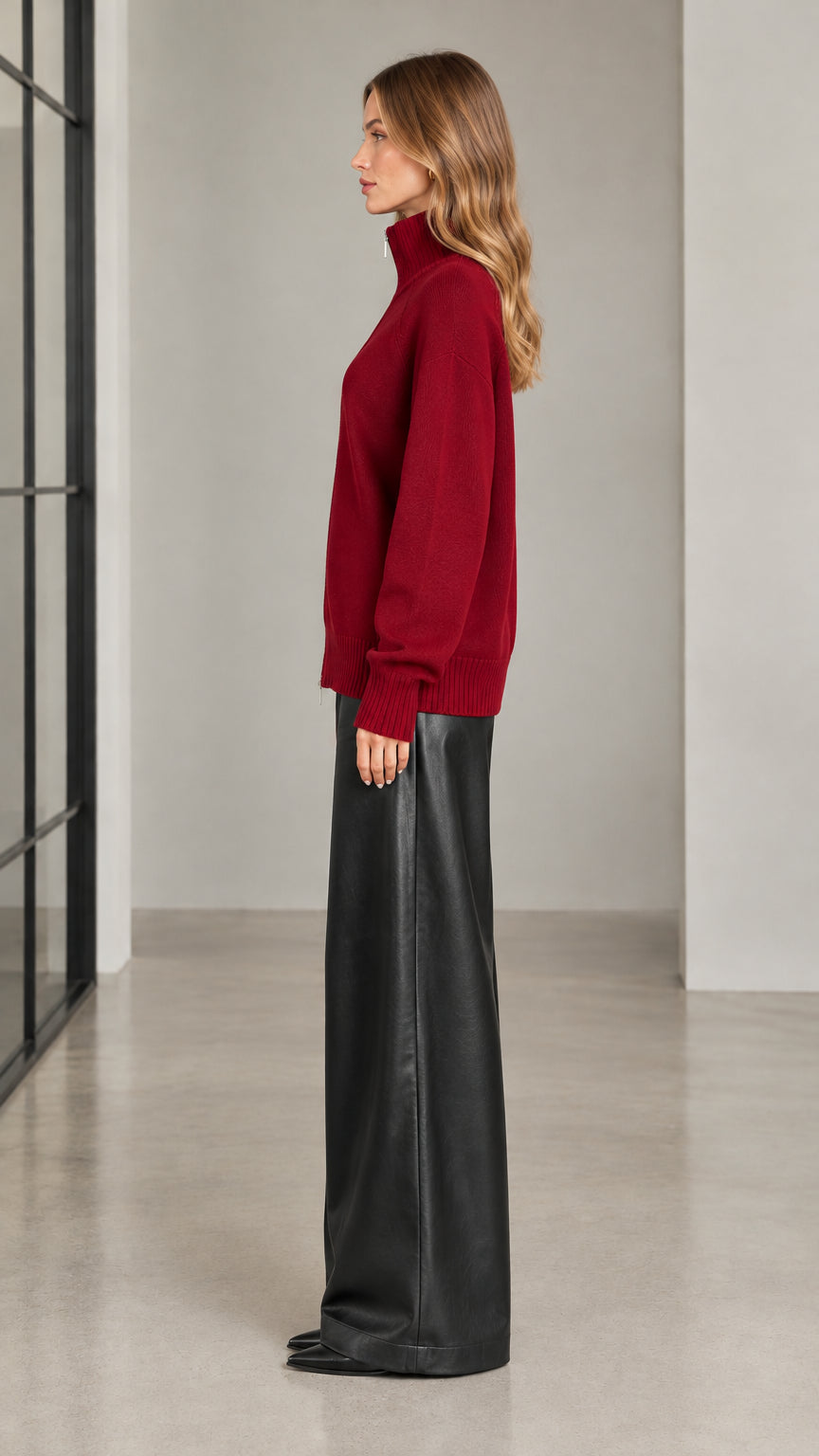 Side profile view of woman wearing burgundy zip front knit sweater