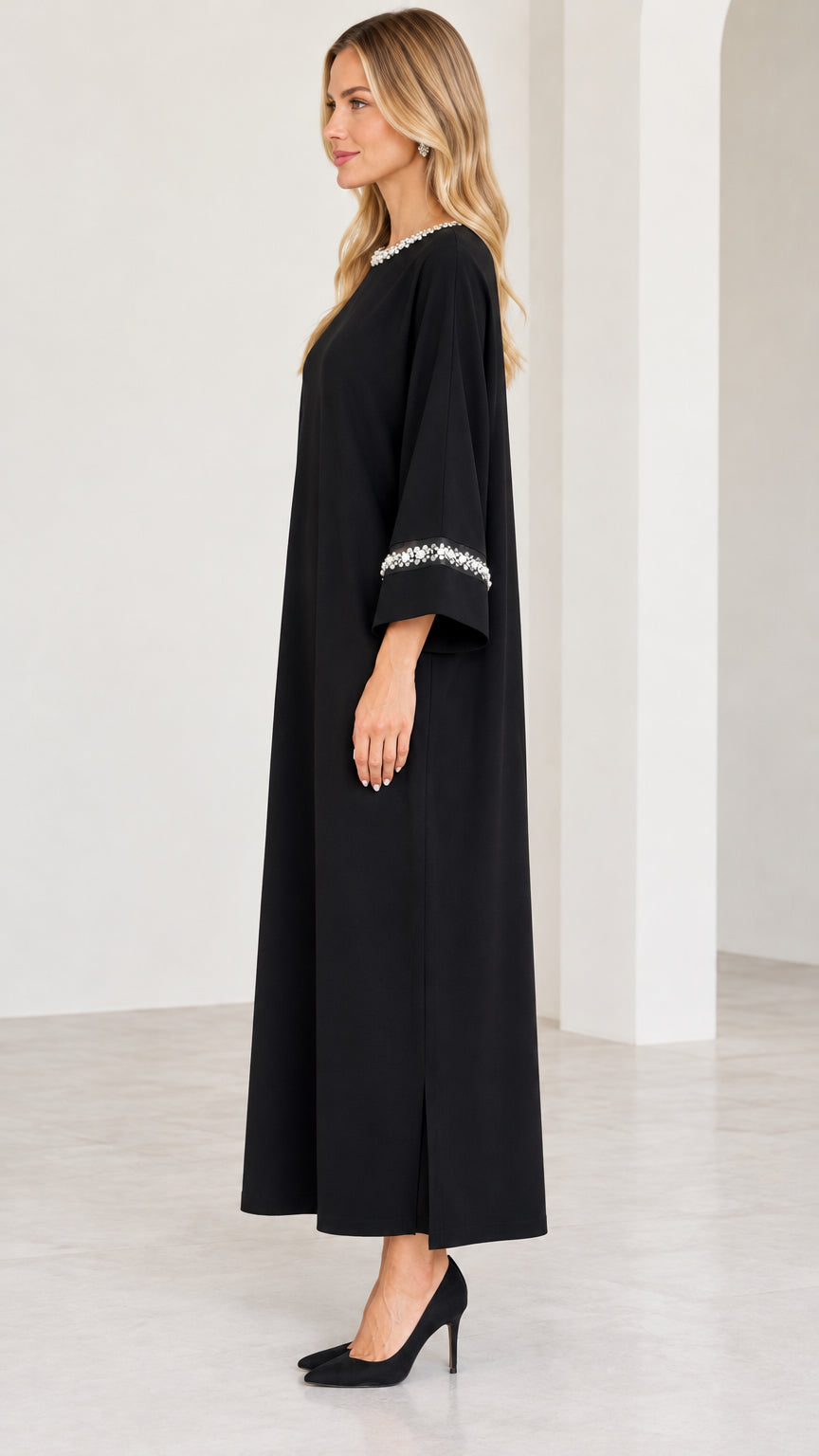 Side profile of model in black long-sleeve modest maxi dress with side slit