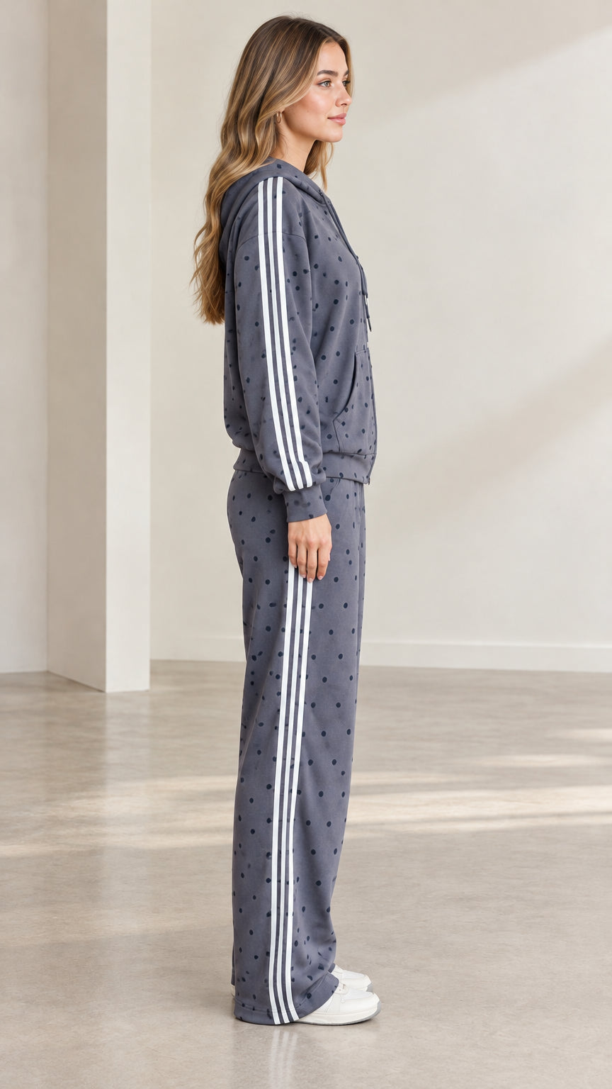 Side profile view showing side stripes on charcoal grey zip hoodie and wide-leg sweatpants