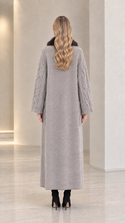 Back view of woman wearing grey maxi length cable knit coat