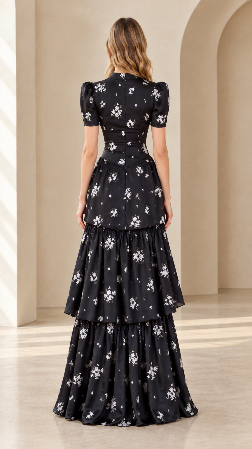Back view of model wearing black floral tiered maxi dress with puff sleeves
