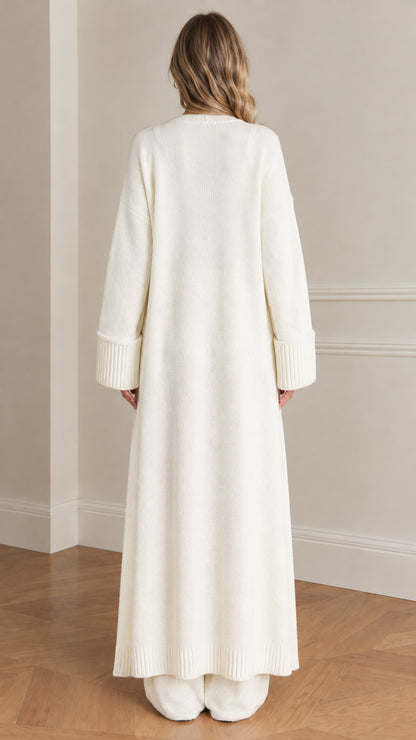 Back view of woman wearing cream floor-length duster cardigan and knit pants