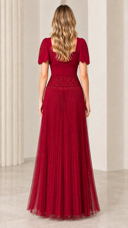 Back view of woman wearing burgundy square back pleated formal gown with bolero jacket