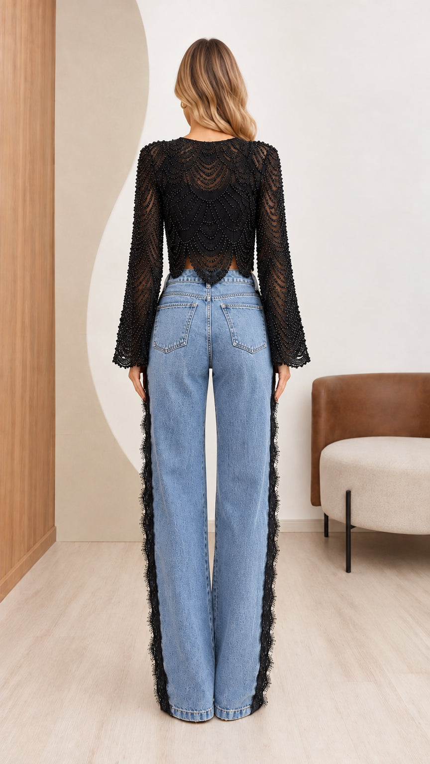 Back view of model wearing black beaded crop top and side-trimmed wide-leg jeans
