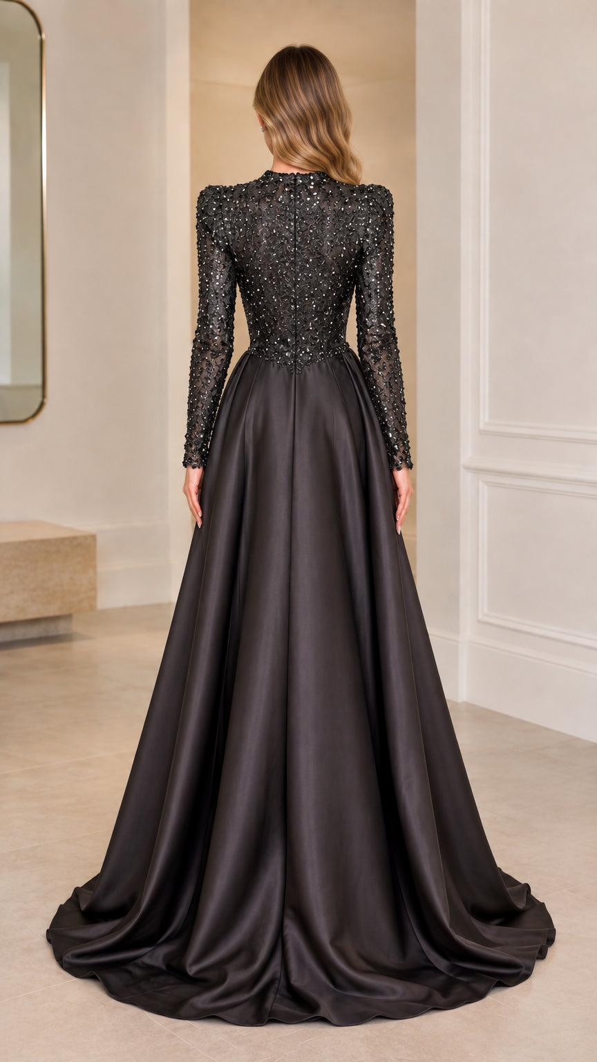 Back view of black long sleeve sequin gown displaying the flowing satin train