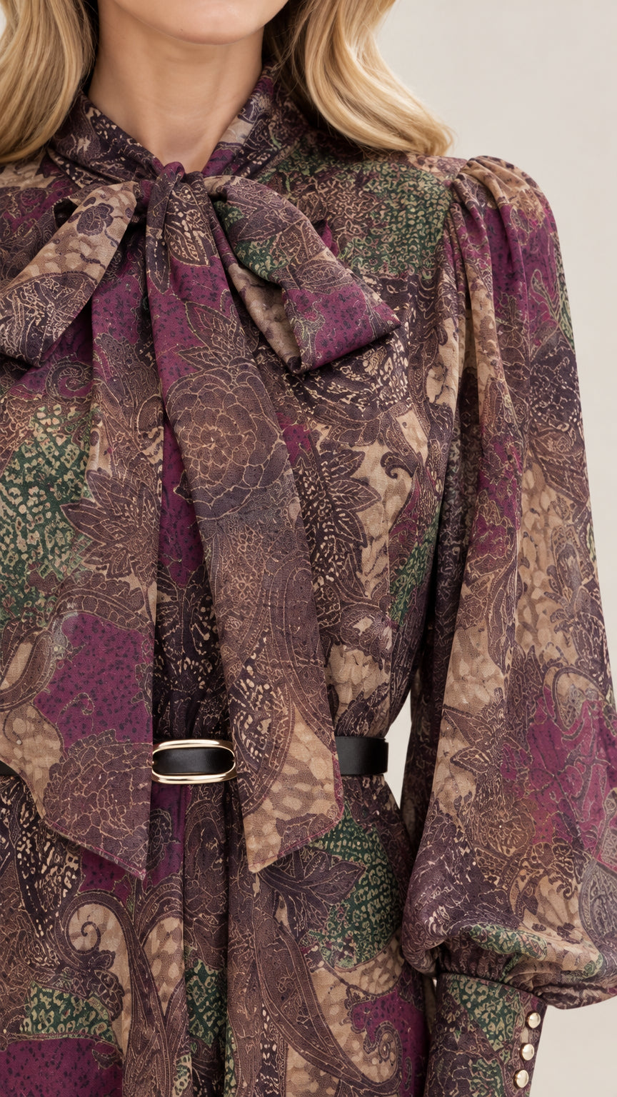 Close-up detail of self-tie bow neckline and intricate paisley pattern
