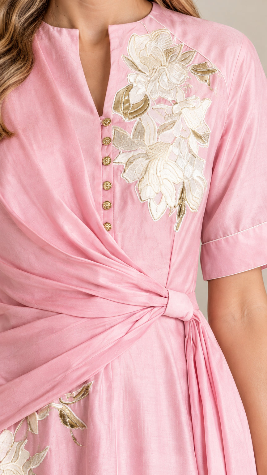 Close-up detail of floral embroidery and twist waist on pink dress