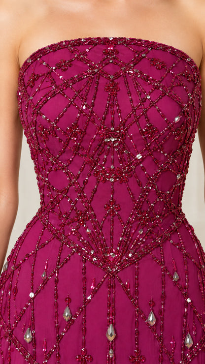 Close-up detail of geometric beading and crystal accents on magenta gown
