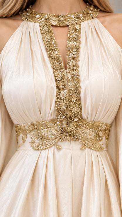 Close-up detail of ornate gold floral embroidery on champagne halter neckline and waist