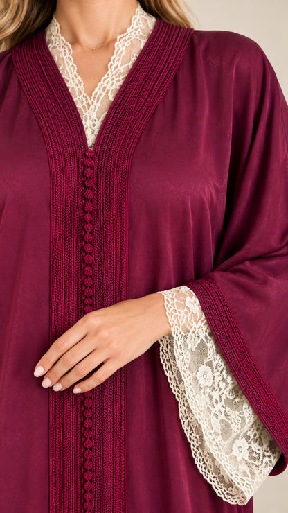 Close-up of burgundy abaya showing floral lace trim and delicate front button details