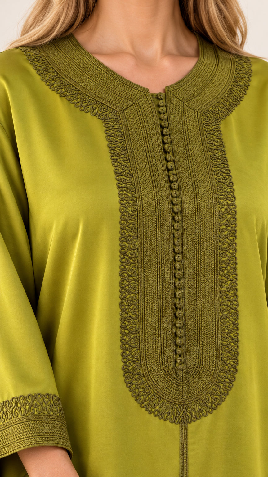 Close-up detail of embroidery and button trim on olive green kaftan neckline and sleeve