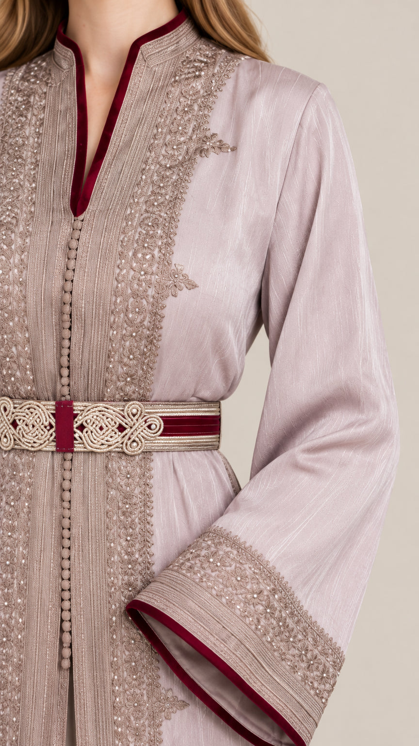 Close-up detail of ornate gold embroidery, contrast trim, and belt on dusty lilac kaftan