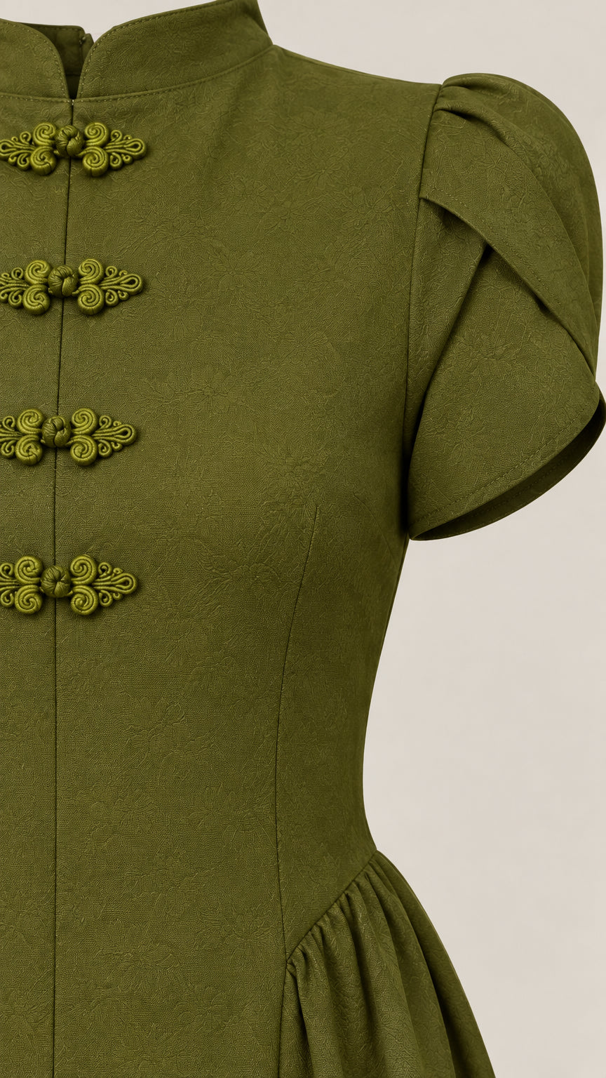 Close-up detail of mandarin collar, traditional frog buttons, and puff sleeve on olive green dress