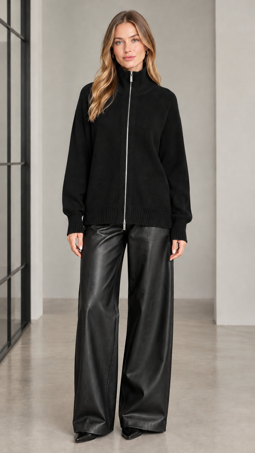 Front view of woman wearing black full zip high neck knit sweater