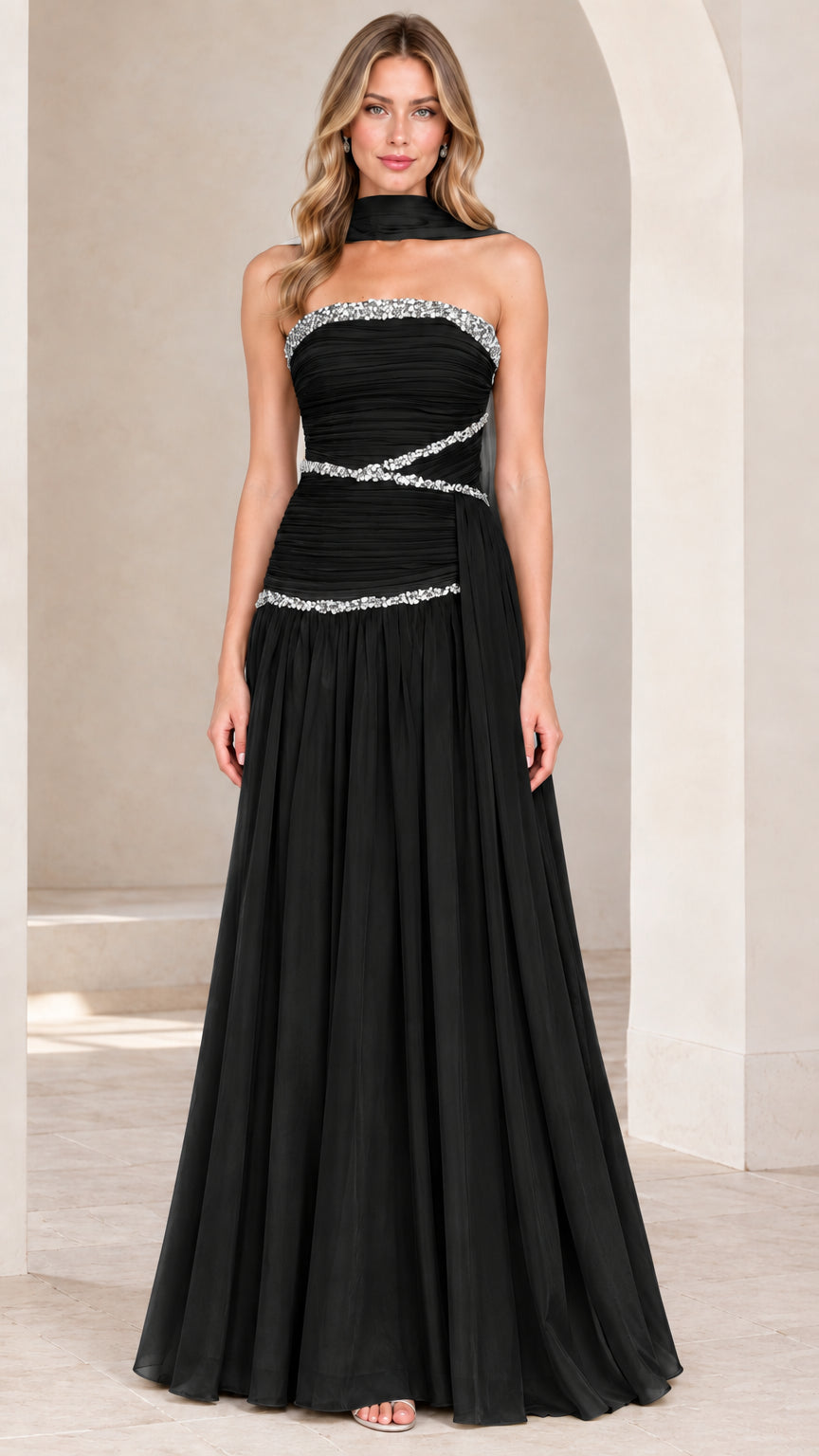 Front view of model wearing black strapless rhinestone ruched chiffon evening gown