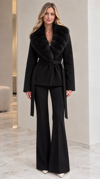 Model wearing black belted wrap coat with matching dark fur collar