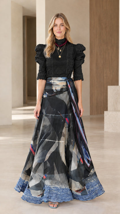Full-length view of black puff sleeve top and charcoal abstract print maxi skirt