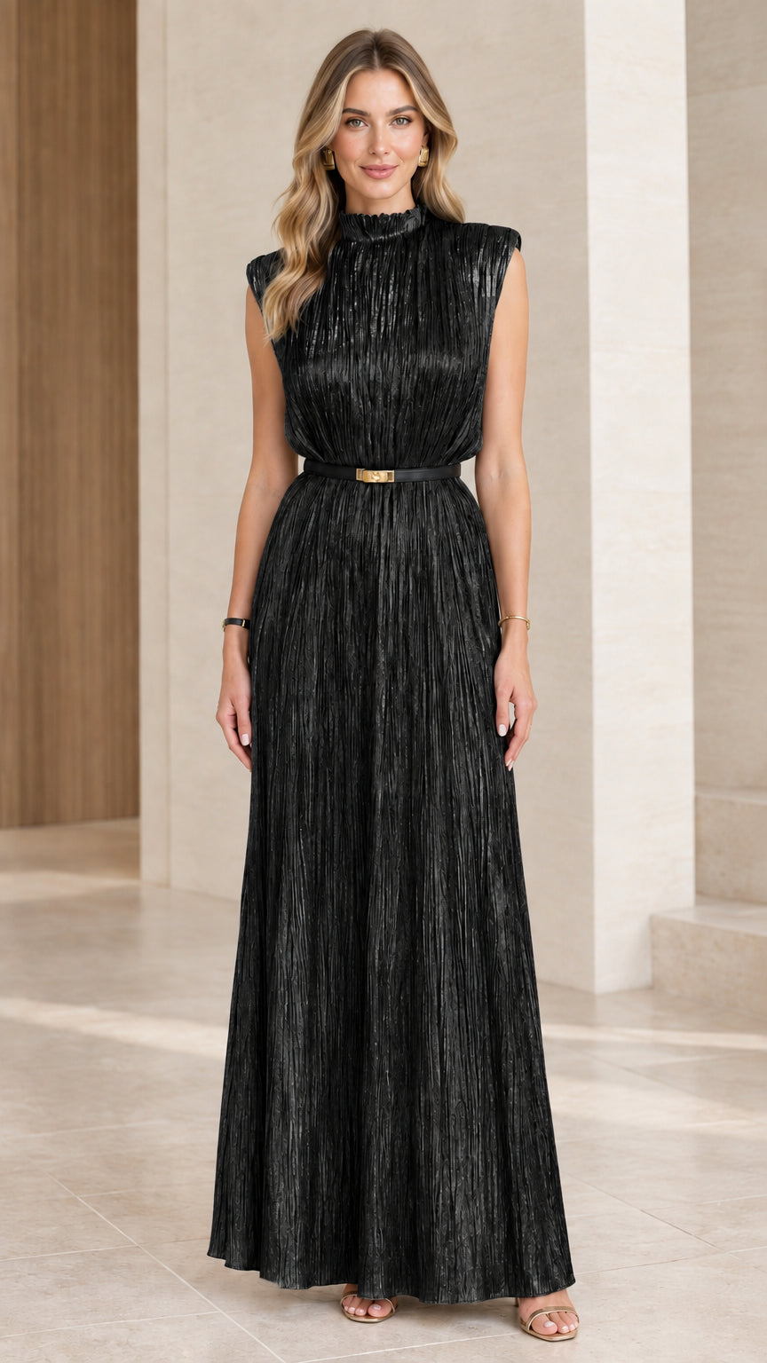 Model wearing black sleeveless pleated metallic maxi dress with belt
