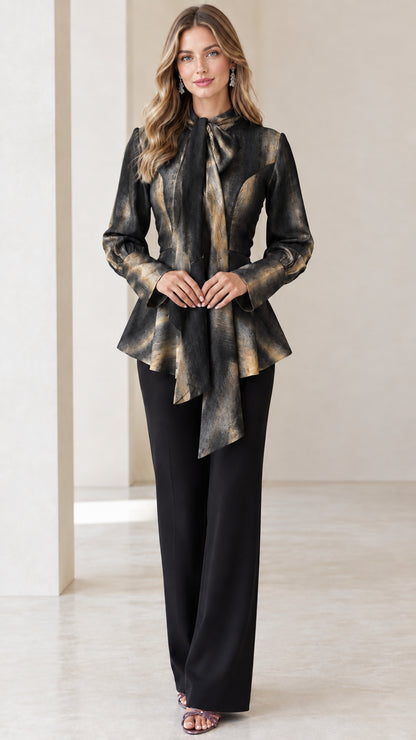 Model wearing Charcoal Gold watercolor long sleeve tie-neck peplum top with black trousers