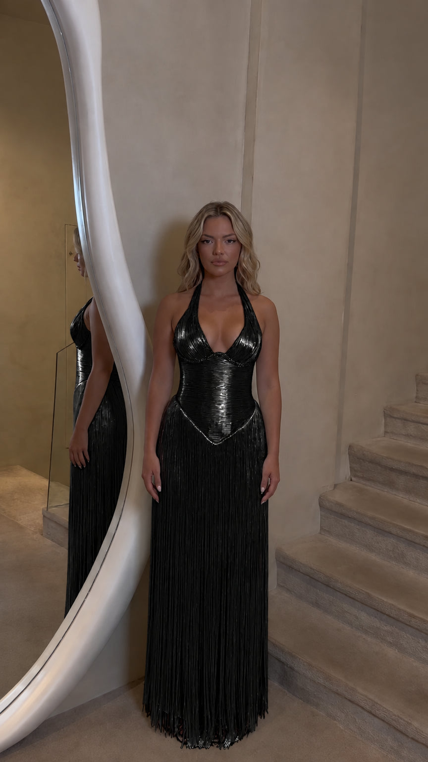 Front view of model wearing black halter corset fringe maxi dress