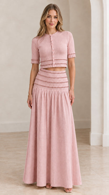 Model wearing blush pink beaded crop top and pleated maxi skirt set