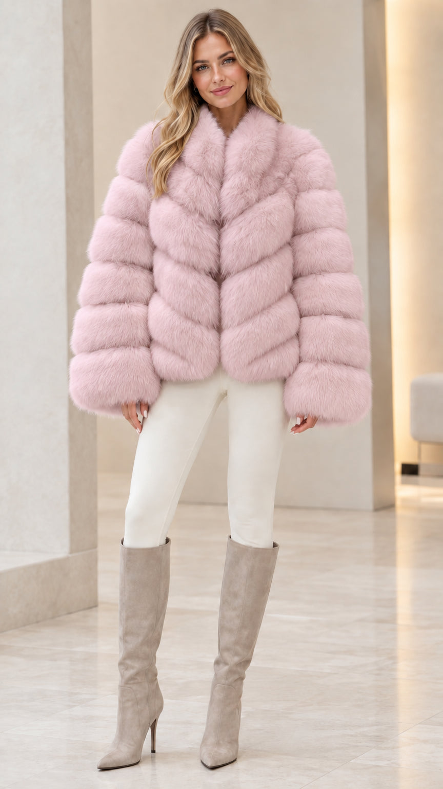 Model posing in blush pink horizontal paneled faux fur coat